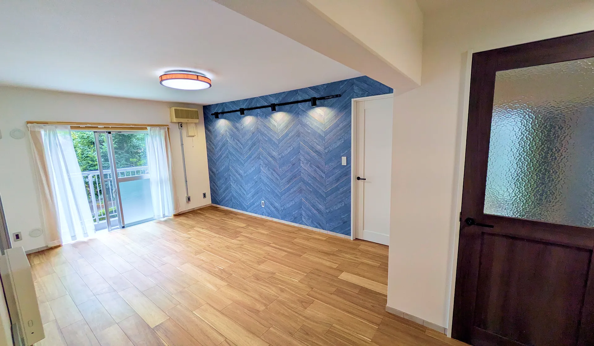 ヘリンボーン柄のアクセントウォールがおしゃれなリビングリフォーム。開放的な空間デザイン。