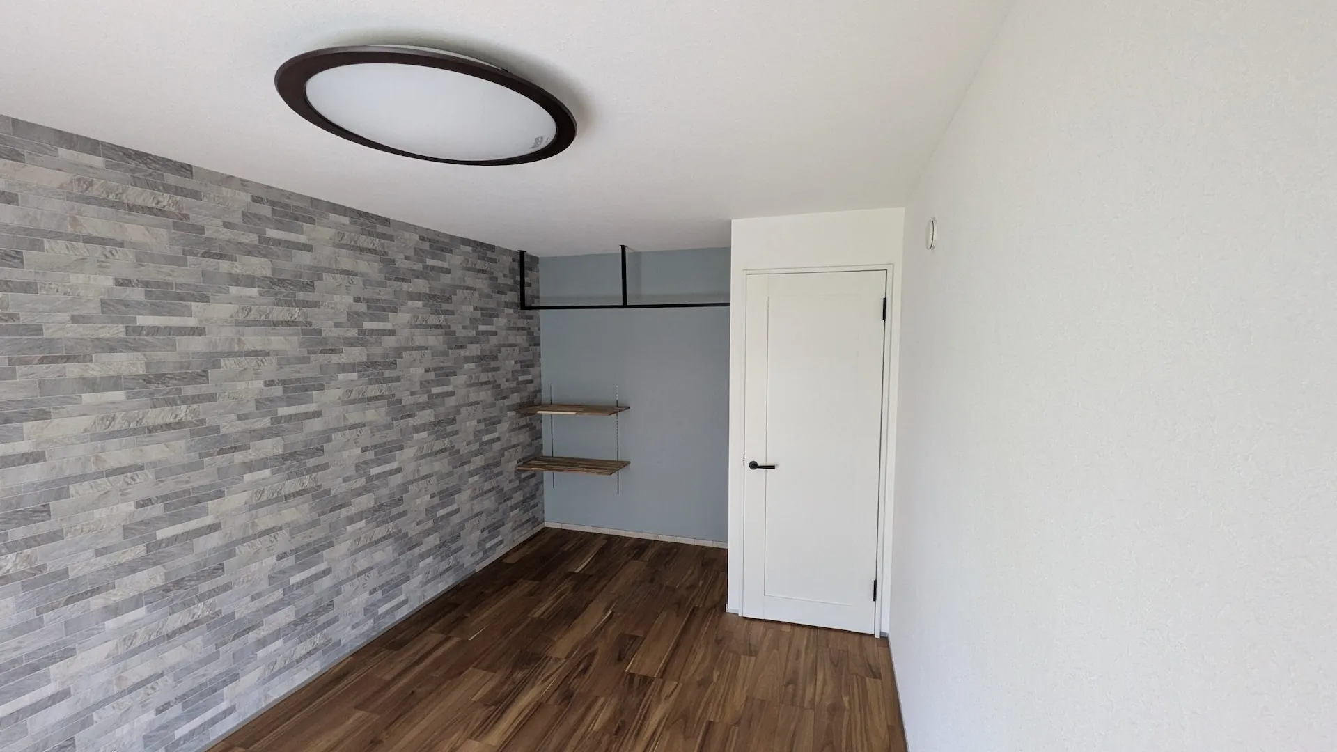 グレーの石目調エコカラット壁とアイアンバーのオープンクローゼット