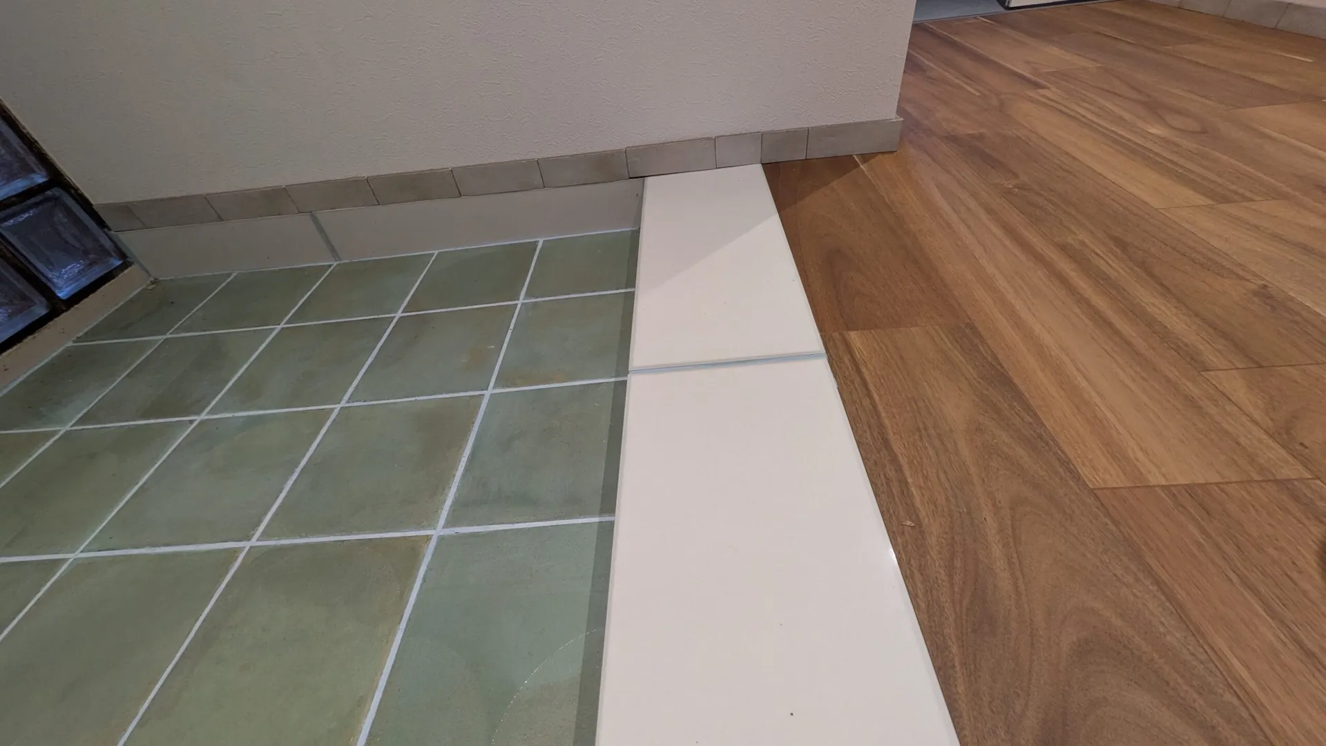 玄関のグリーンタイルと廊下のフローリングの境目