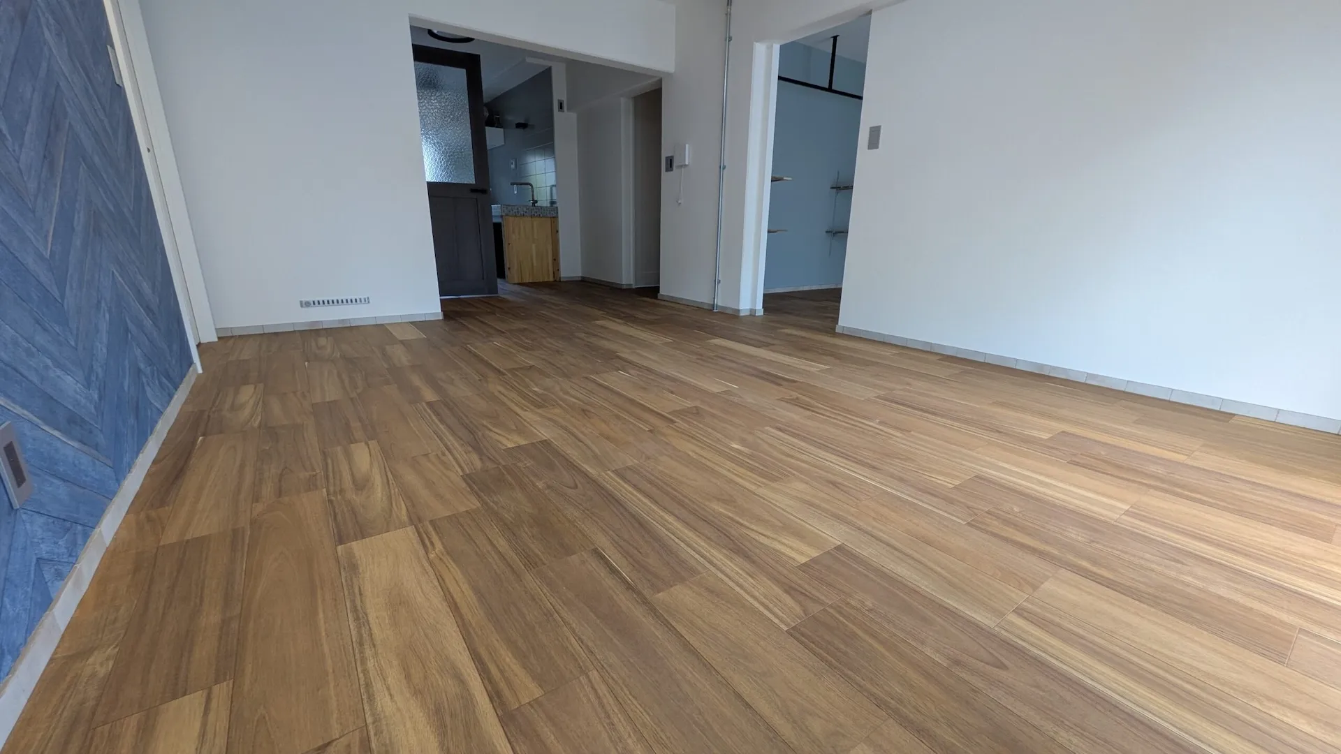 ヘリンボーン柄のアクセントウォールがおしゃれなリビング。開放的な空間デザイン。