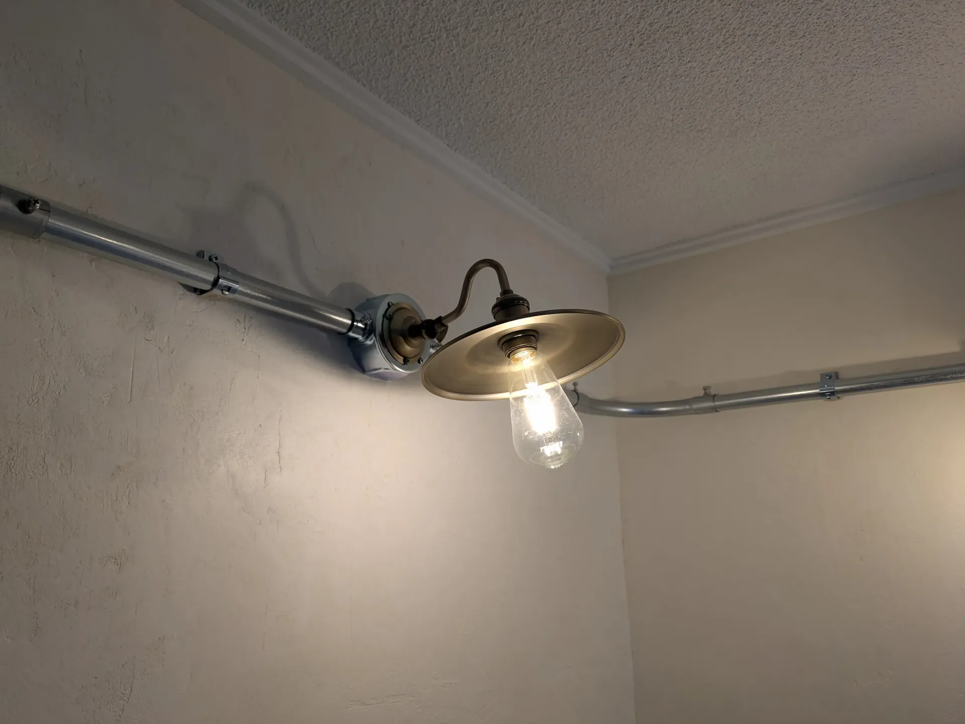 無骨でおしゃれな金属パイプと裸電球の照明演出