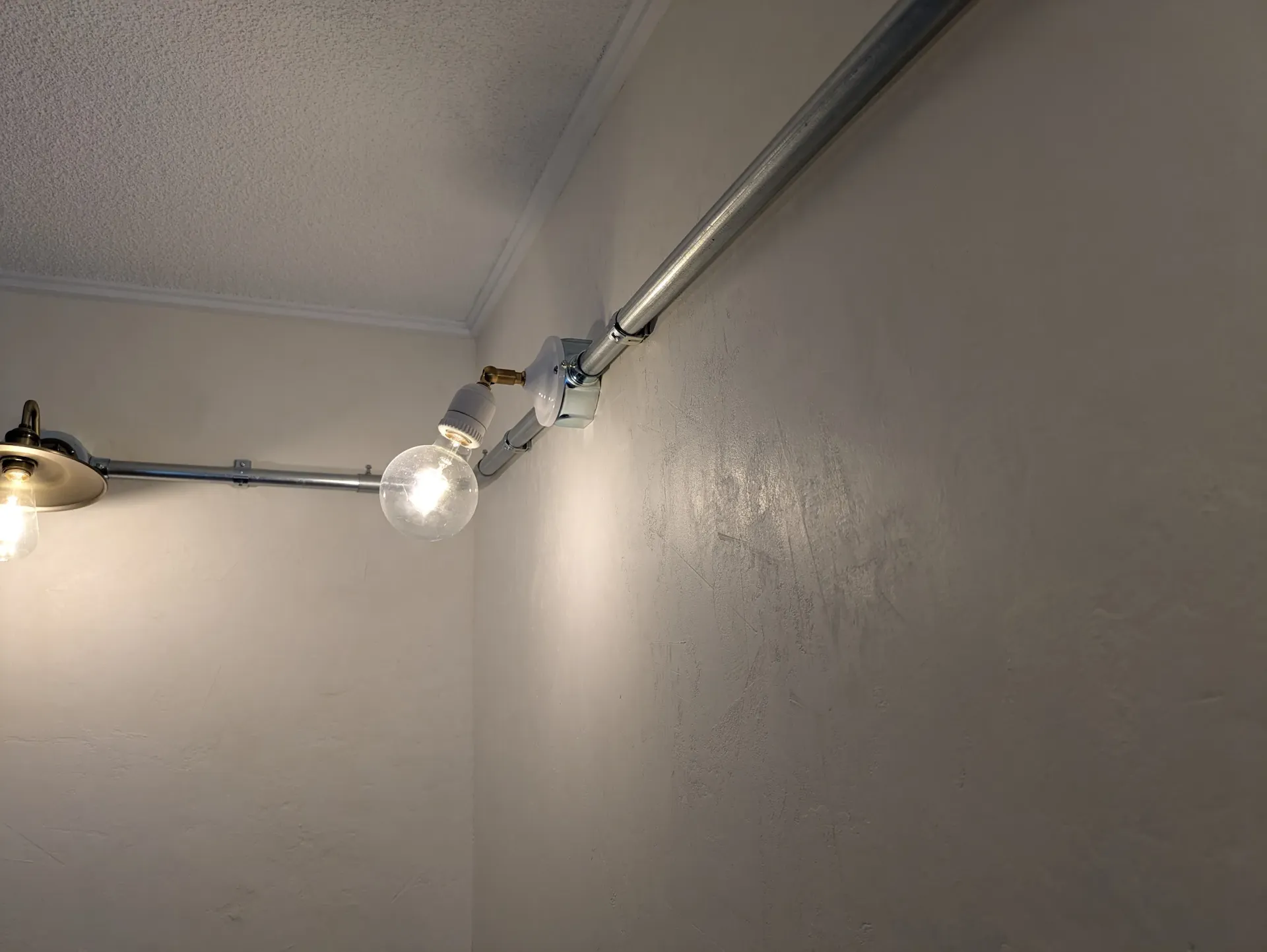 無骨でおしゃれな金属パイプと裸電球の照明演出